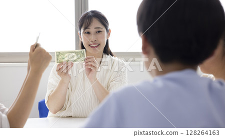 Elementary school students learning about money 128264163