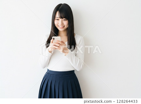 A Japanese woman operating a smartphone (white background, for cutting out) 128264433