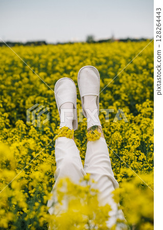 Enjoying a sunny day in a vibrant yellow flower field with relaxed feet 128264443