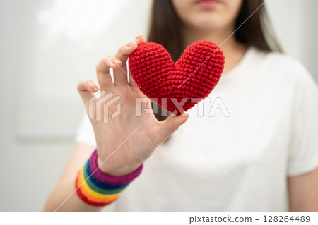 Asian LGBT woman holding heart rainbow flag. 128264489
