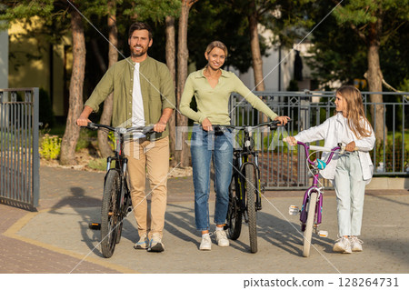Parents and child with bicycles ready for outdoor ride at home Parents and child with bicycles ready for outdoor ride at home 128264731