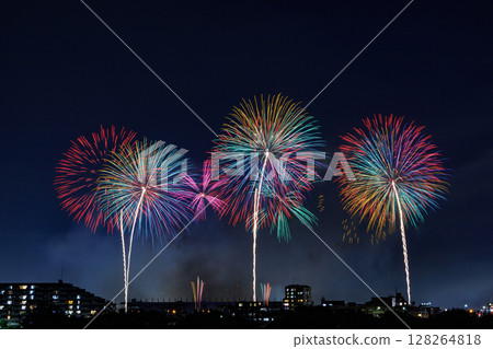 A large flower of colorful light blooming in the night sky 128264818