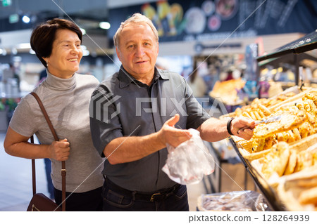 couple chooses sweet puffs in bakery 128264939