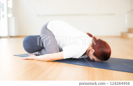 Pregnant woman doing yoga. Woman pose or Balasana Pregnant woman doing yoga. Woman pose or Balasana 128264956