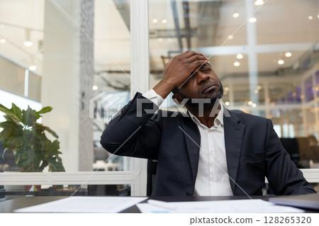 African american businessman having a headache after a busy working day African american businessman having a headache after a busy working day 128265320