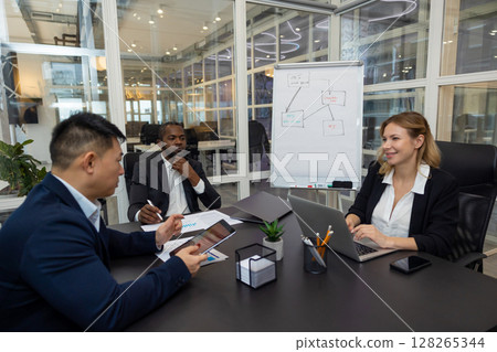 Colleagues working on a new project in the office and discussing the ideas Colleagues working on a new project in the office and discussing the ideas 128265344