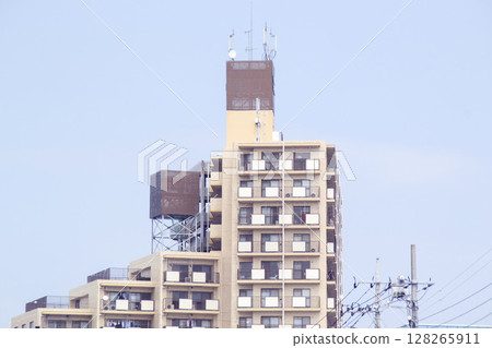An urban building with remnants of advertising billboards and antennas visible on the rooftops 128265911