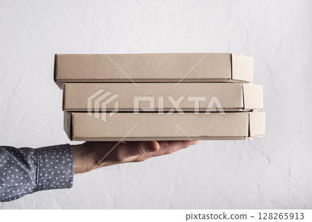 Caucasian male hands hold three pizza boxes side view with copy-space Caucasian male hands hold three pizza boxes side view with copy-space 128265913