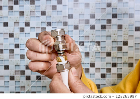Compression ring is positioned by plumber on pipe section before tightening coupling that joins multilayer pipes in water supply system. 128265987