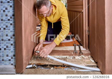 Pipe section is joined with compression fitting above exposed area of floor. 128266016