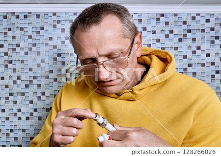 Plumber applies plumbing paste to pipe end to ease insertion of internal support while compression ring of compression coupling is already in place. 128266026