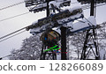 積雪覆蓋的纜車柱和載著滑雪者的纜車經過 128266089