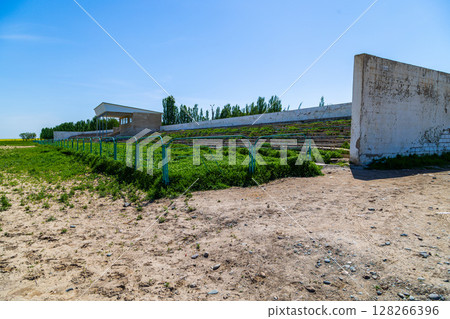Overgrown wooden bleachers in Kok-Boru stadium Overgrown wooden bleachers in Kok-Boru stadium 128266396