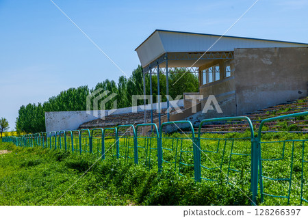 Overgrown wooden bleachers in Kok-Boru stadium in Kyrgyzstan Overgrown wooden bleachers in Kok-Boru stadium in Kyrgyzstan 128266397