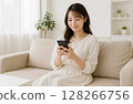 A woman watching a smartphone 128266756