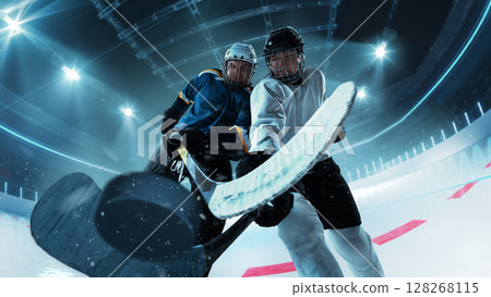 Close-up action shot of hockey players competing for puck on 3D ice rink 128268115
