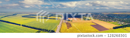 Sunny day in the countryside. Rural landscape in daylight. Aerial view of the countryside, country road, fields, and beautiful cloudy sky Sunny day in the countryside. Rural landscape in daylight. Aerial view of the countryside, country road, fields, and beautiful cloudy sky 128268301