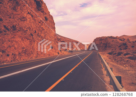 Driving a car on mountain road in desert. View of sandstone mountains through windscreen. Israel 128268768