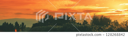Silhouette of the mountain against the sunset sky. The Hula Valley in northern Israel at sunset. Horizontal banner 128268842