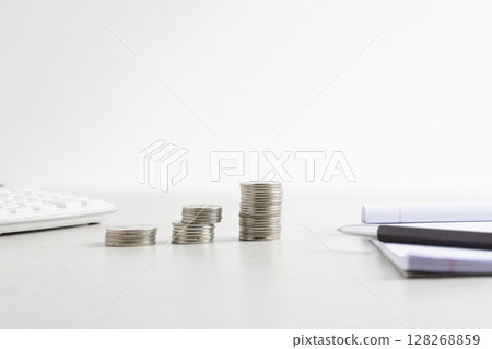 Coins and objects on a table with a financial and economic concept. Coins and objects on a table with a financial and economic concept. 128268859