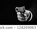 A hand holding gun on dark background, threat, danger, and crime 128269063