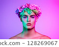 Model posing with flower crown and neon lighting effects 128269067