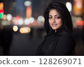 Young indian woman smiling in city at night 128269071