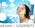 Woman enjoying sun on sailboat in ocean during summer vacation 128269073