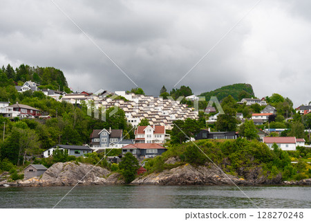 Modern hillside housing in green coastal suburb of Bergen Norway under cloudy sky Modern hillside housing in green coastal suburb of Bergen Norway under cloudy sky 128270248