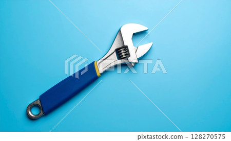 Adjustable metal wrench, a versatile silver hand tool for repair and construction, isolated on a blue background Adjustable metal wrench, a versatile silver hand tool for repair and construction, isolated on a blue background 128270575