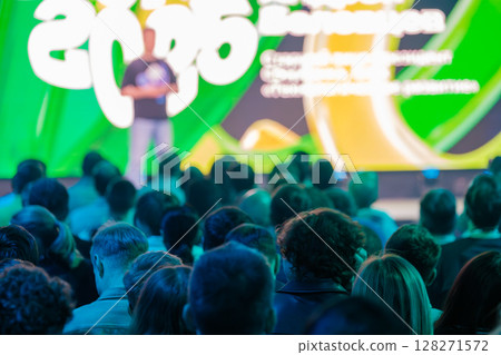 Colorful business presentation audience with focused crowd and vibrant background 128271572