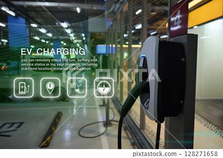 Smart electric vehicle charging station in a modern parking area with digital interface and green energy icons 128271658