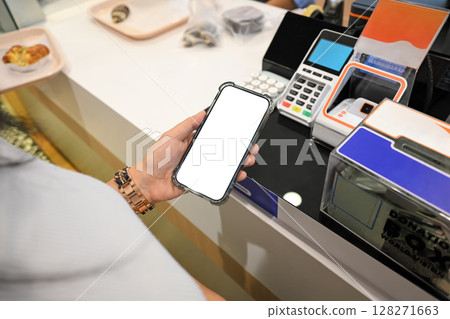 Customer holding a smartphone, make a digital payment using contactless technology Customer holding a smartphone, make a digital payment using contactless technology 128271663