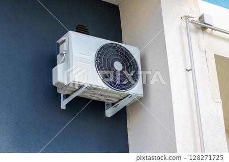 An air conditioning unit that is mounted on the side of a building 128271725