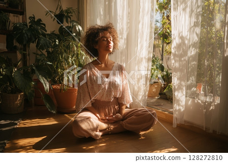 Meditation Session in a Sunlit Room Surrounded by Plants During the Morning Hours 128272810