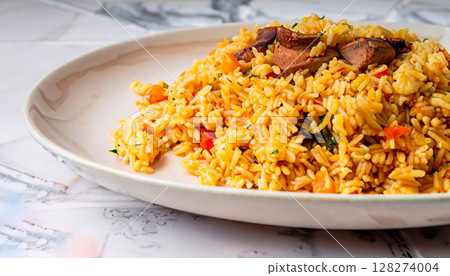 macro photo of pilaf in a plate on a white marble serving table 128274004