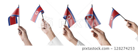 The North Korea flag in hand in different angles on a white background The North Korea flag in hand in different angles on a white background 128274253