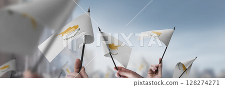 Cyprus flags in their hands on a blurred urban background 128274271