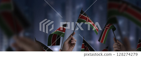 Kenya flags in their hands on a blurred urban background Kenya flags in their hands on a blurred urban background 128274279