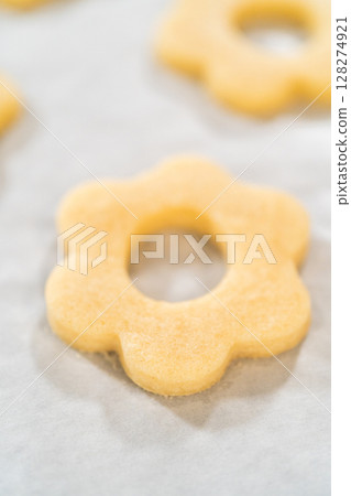 Detailed view of a baked flower sugar cookie with center cutout. Ideal for assembling Easter Cookie Sandwich with Raspberry Buttercream. 128274921