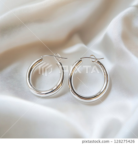 Silver hoop earrings photographed on a white background 128275426