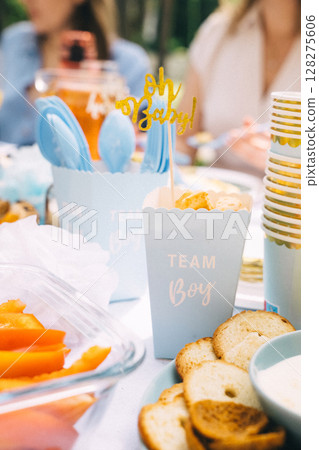 Sweet treats and savory snacks at a sunny baby shower gathering Sweet treats and savory snacks at a sunny baby shower gathering 128275606