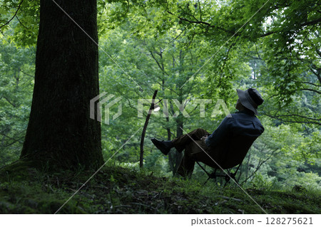 A man enjoying the quiet sunset at a solo camp A man enjoying the quiet sunset at a solo camp 128275621