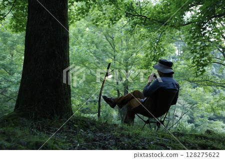 A man enjoying the quiet sunset at a solo camp 128275622