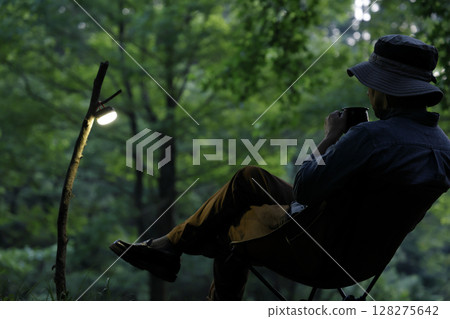 A man enjoying the quiet sunset at a solo camp A man enjoying the quiet sunset at a solo camp 128275642