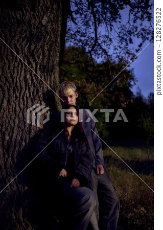 two 15-year-old teenagers in love under old majestic oak in an autumn park two 15-year-old teenagers in love under old majestic oak in an autumn park 128276522