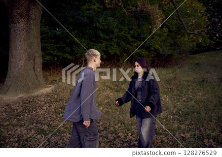 two 15-year-old teenagers in love play, hug , spend time together in an autumn park 128276529