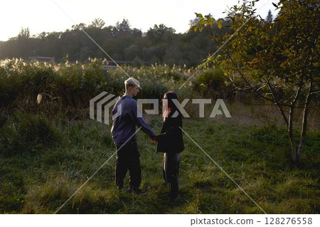 15-year-old teenage couple in love playing in  reeds at sunset 128276558
