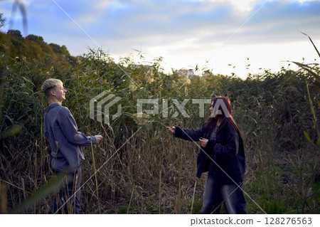 15-year-old teenage couple in love playing in  reeds at sunset 128276563