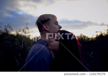 A 15-year-old teenage couple in love hugs and kisses at sunset A 15-year-old teenage couple in love hugs and kisses at sunset 128276570